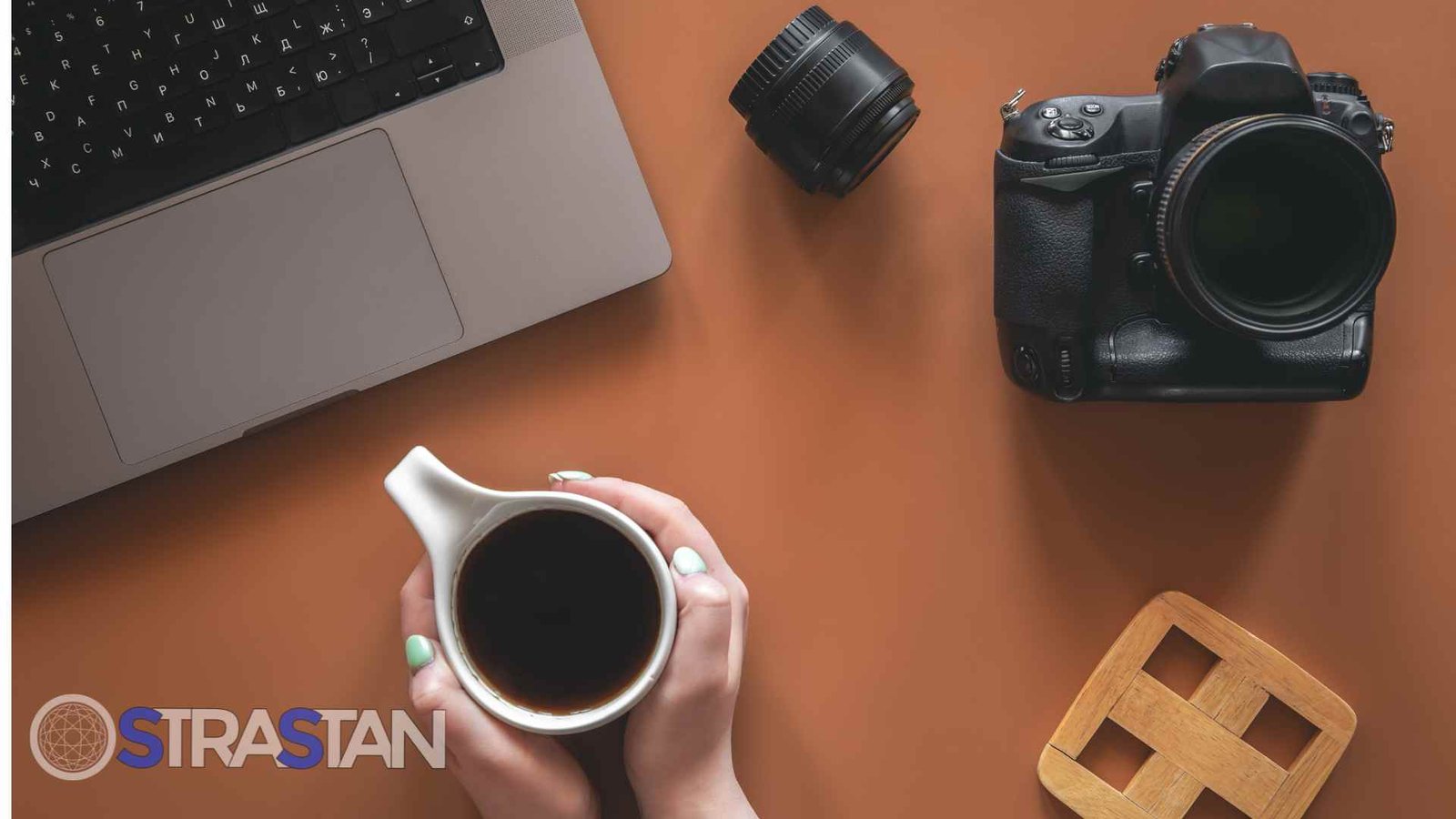 A creative's workspace viewed from above, illustrating the invisible magic in our everyday technology. While a photographer holds a warm cup of coffee next to their laptop and DSLR camera, powerful AWS AI works behind the scenes, seamlessly analyzing and organizing thousands of images, turning everyday creative tools into an intelligent, efficient system.