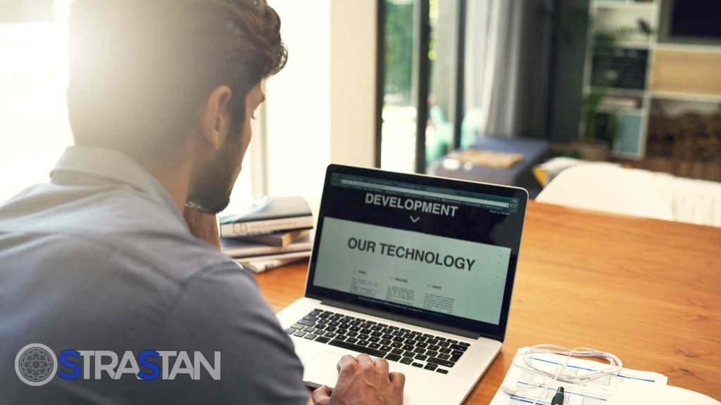 A developer working on a laptop, which displays a website's technology page, representing website development as one of the key SME solutions.