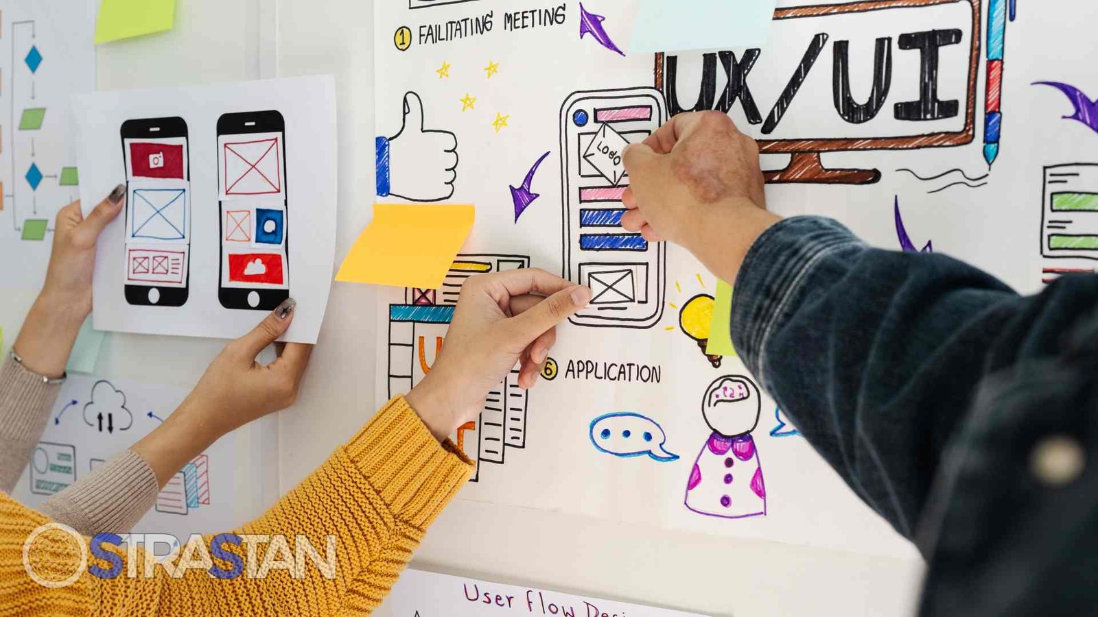 A team of designers collaborating on UI/UX wireframes and web layouts, emphasizing the detailed planning phase of a project.