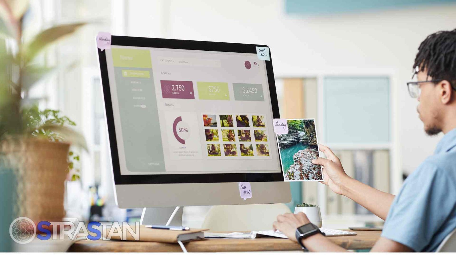 A male developer reviews analytics on a desktop screen, while holding a printed photo, showcasing the data-driven approach of a website development service.