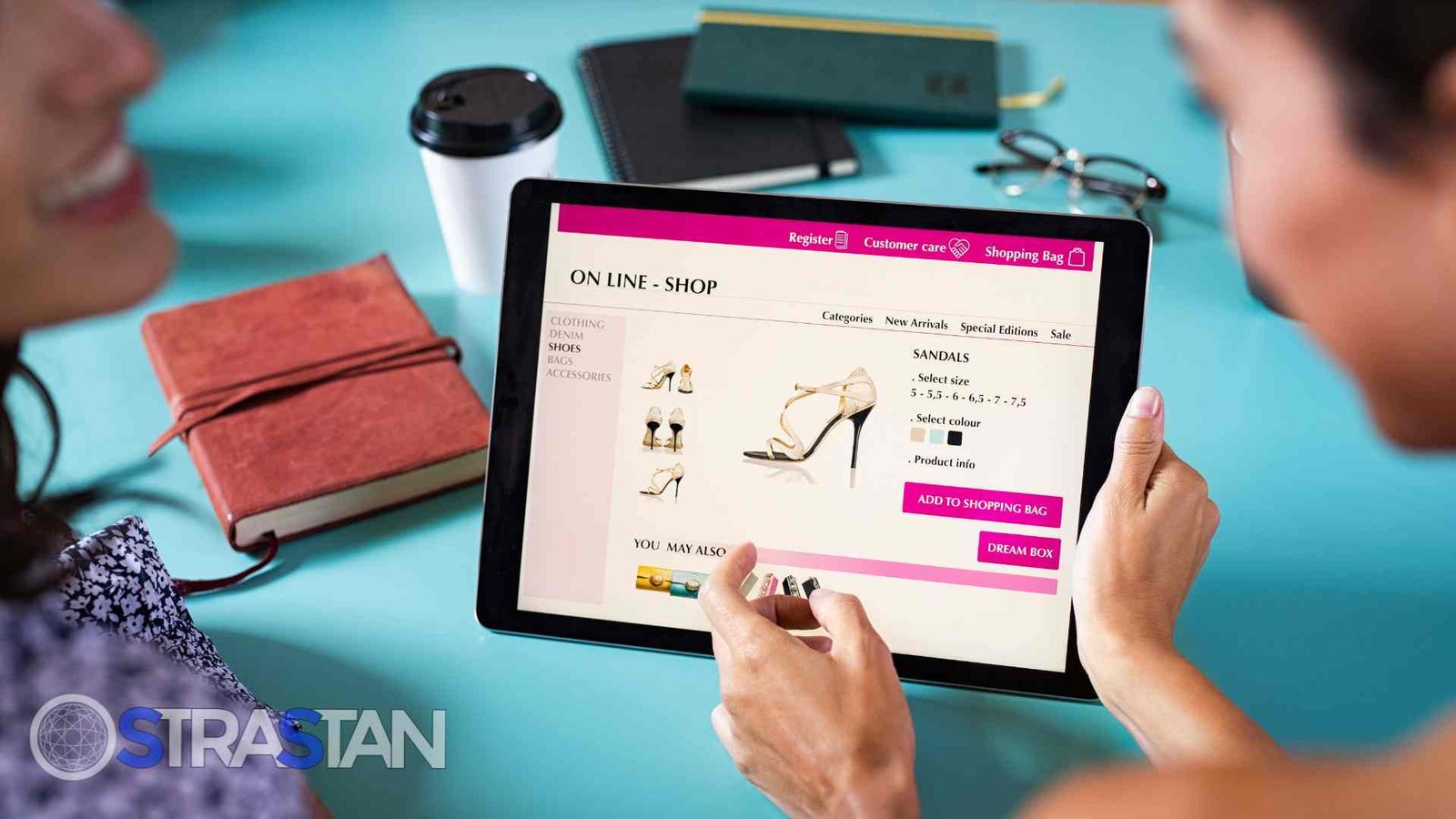 wo people are collaboratively browsing sandals on a tablet, demonstrating how a website development service builds responsive and user-friendly designs for various devices.